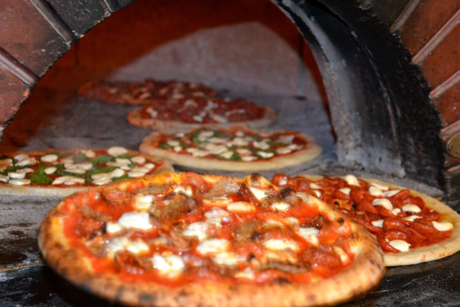 Sourdough pizzas blistering in the wood-fired oven