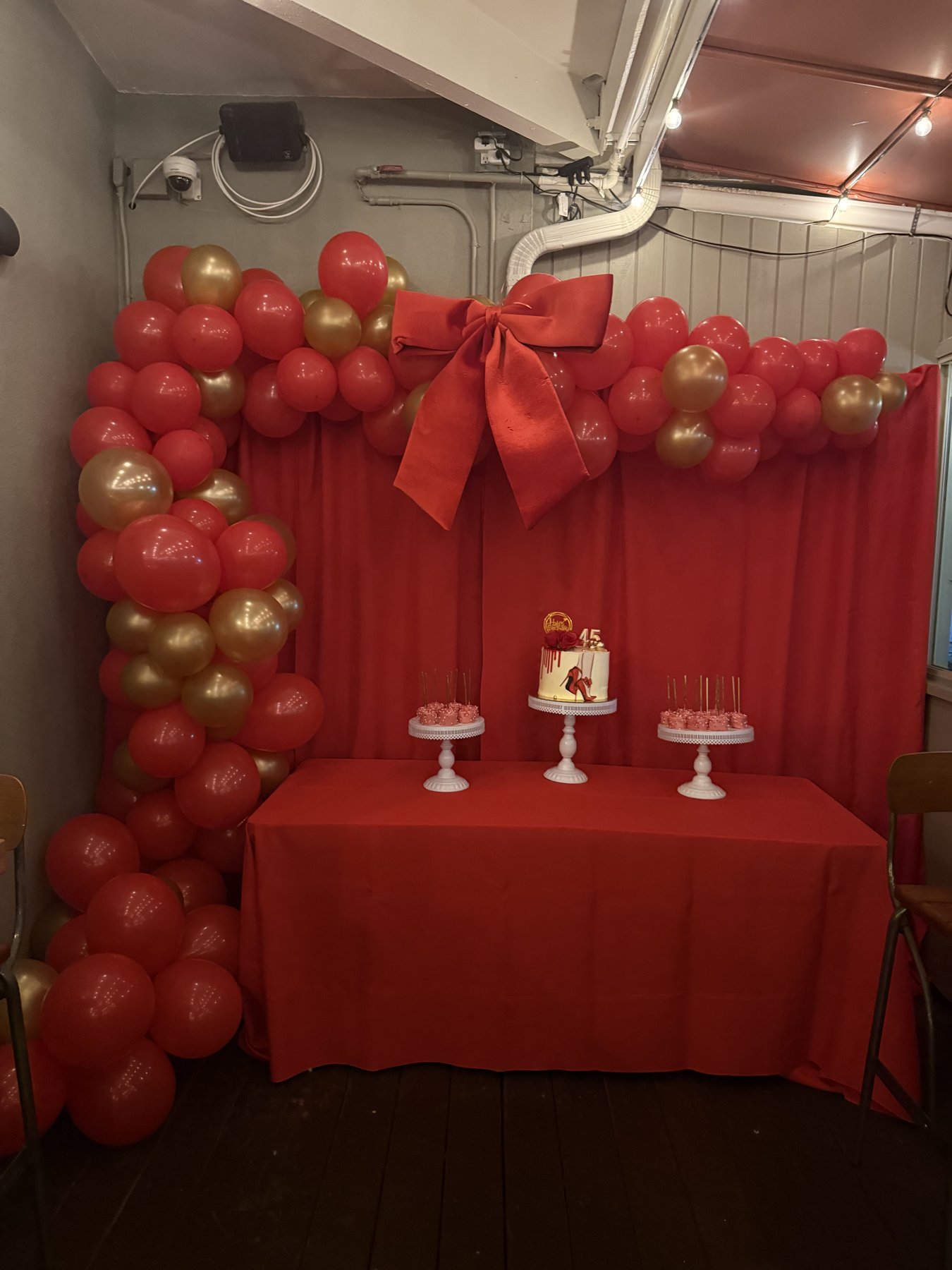 Birthday setup with balloon arch and cake table
